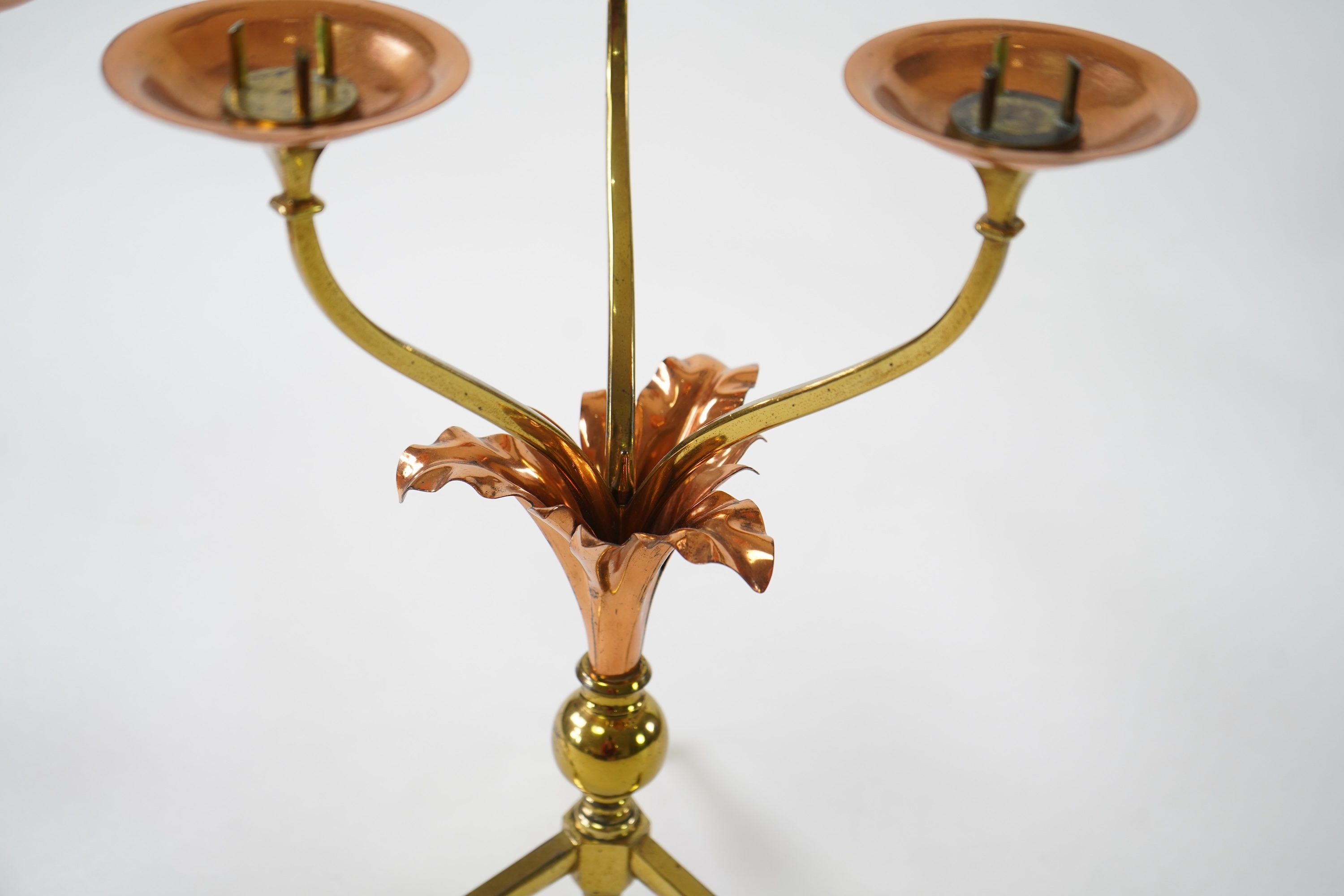 W.A.S. Benson & Co.: A pair of Arts and Crafts gilt brass and copper three branch candelabra